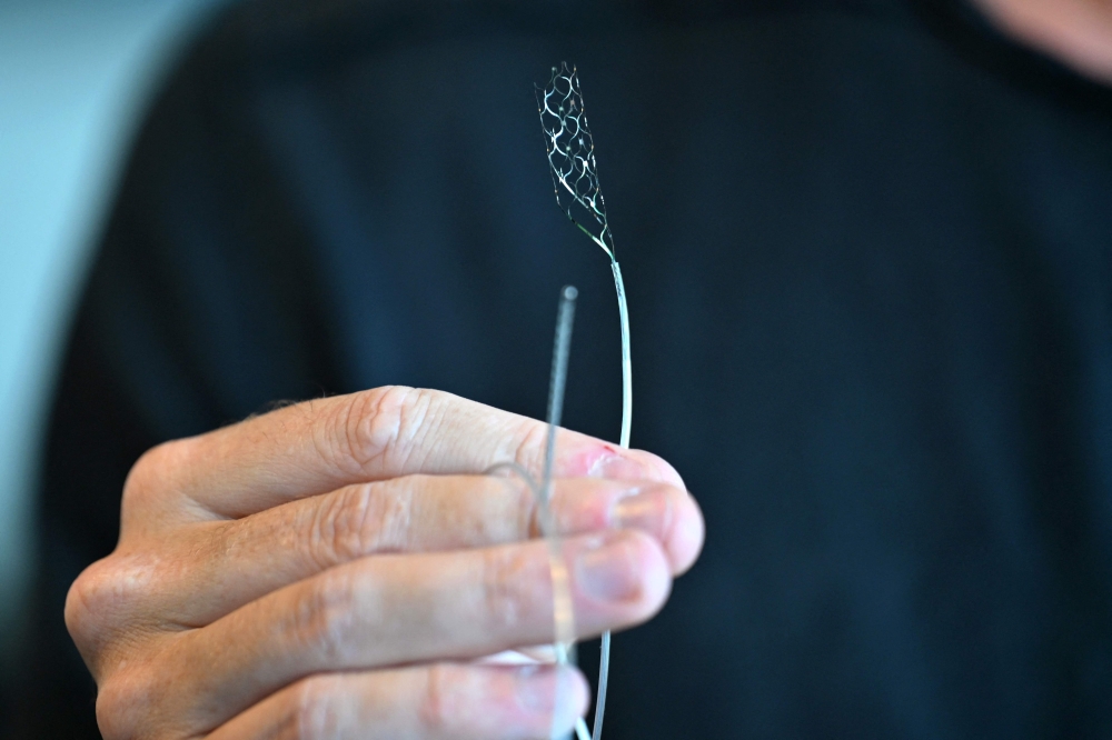 CEO & Founder of, Synchron, Thomas Oxley, holds a stentrode in his office on August 9, 2023, in New York. — AFP pic
