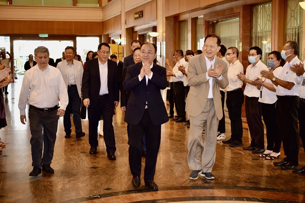 Ouyang (second right) receives a warm welcome upon arrival at Crown Towers. At right is Henry.  —  Borneo Post Online pic