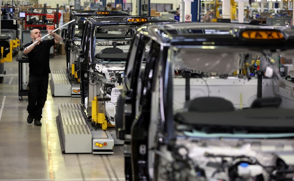 A worker walks along the TX electric taxi production line inside the London Electric Vehicle Company factory in Coventry January 18, 2023. — Reuters pic