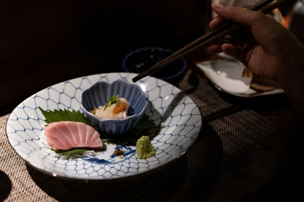 A customer dines on Japanese seafood for dinner at Hassun Japanese restaurant, in Hong Kong July 22, 2023.— Reuters pic
