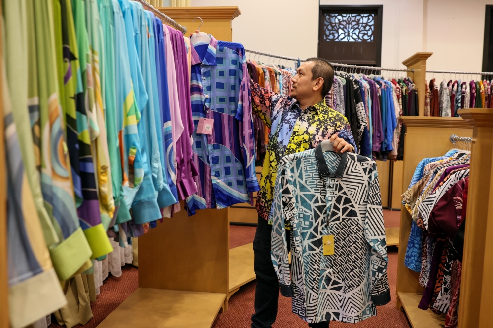 Noor Arfa Holdings Sdn Bhd managing director Wan Mohd Hafiz Wan Mohd Ariffin inspects batik shirts to be sold to customers at the Noor Arfa Craft Complex, Chendering, Kuala Terengganu, August 24, 2023. — Bernama pic 