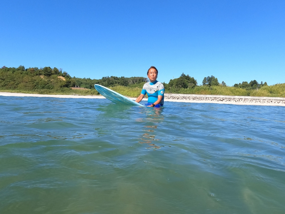 Koji Suzuki rides on his surfing board on the beach in Minamisoma, Fukushima Prefecture August 25, 2023. — Reuters pic