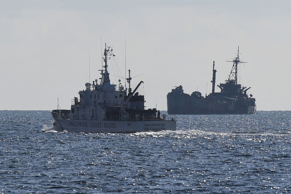 This file photo taken on April 23, 2023 shows Philippine coast guard vessel BRP Malapascua (left) patrolling near the grounded navy ship BRP Sierra Madre where Philippine marines are stationed to assert Manila's territorial claims at Second Thomas Shoal in the Spratly Islands. — AFP