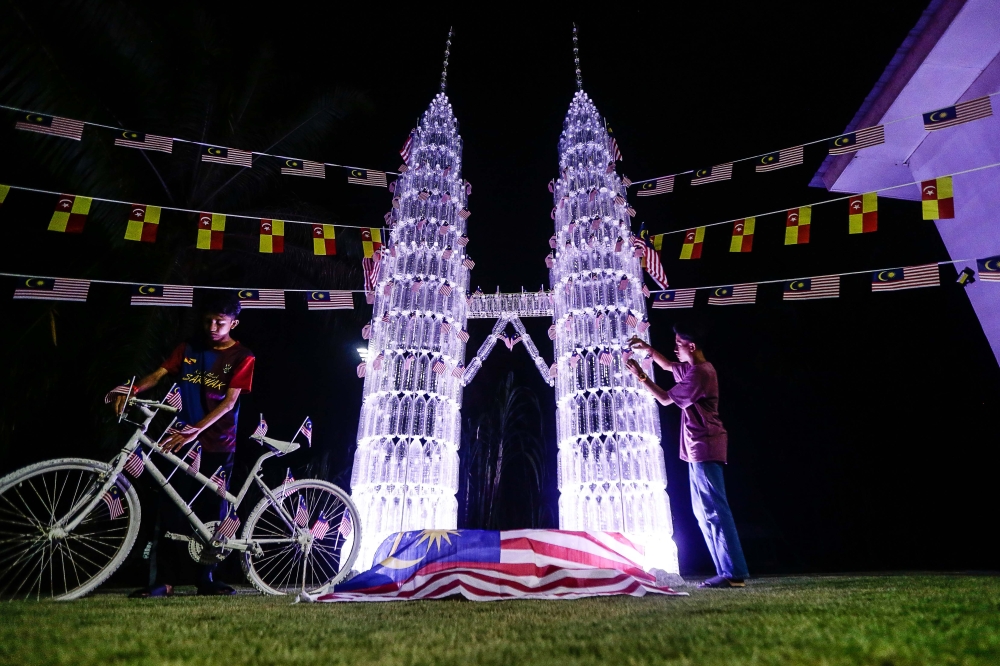 Ahmad Afiq Mohd Zailani and his brother Ahmad Afif Mohd Zailani adjust the sculpture they made for the school contest they entered at their home in Tanjung Karang, August 28, 2023. — Picture by Sayuti Zainudin