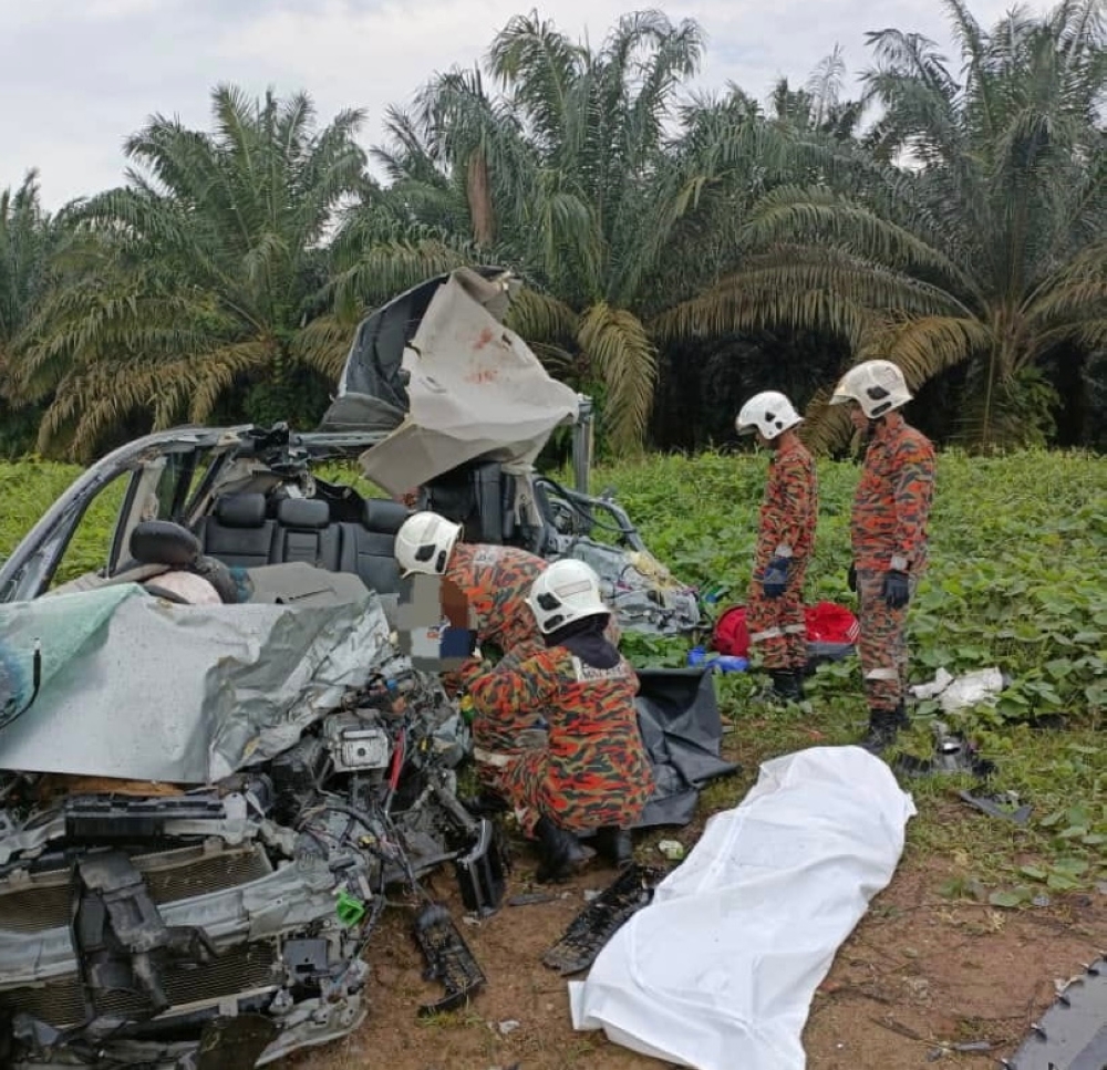 Firemen attempt to extricate the bodies from the mangled wreck of the Honda Freed at Ladang Cenas, Bandar Tenggara in Kota Tinggi August 28, 2023. — Picture courtesy of the Johor Fire and Rescue Department