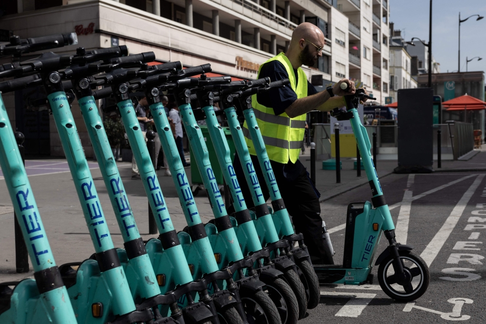 An employee loads electric scooters in a van in Paris on August 23, 2023. — AFP pic
