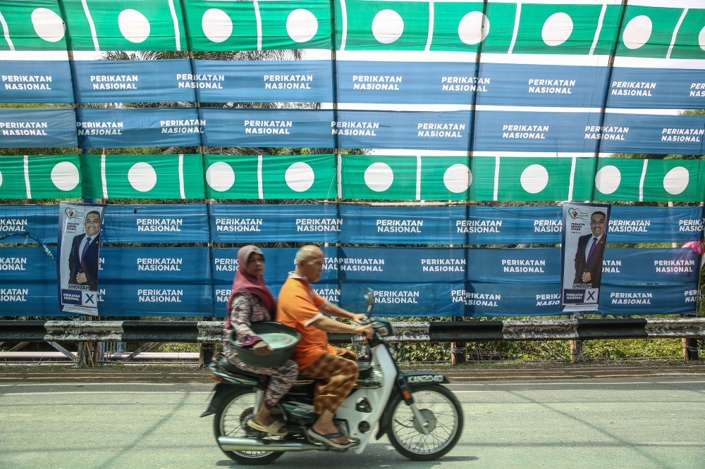 PAS and PN flags in conjunction with the Kedah 15th state election at Kampung Hujung Bandar in Sik, Kedah August 7, 2023. One young voter doesn’t agree with political parties dragging race and religious issues into the picture. — Picture by Yusof Mat Isa