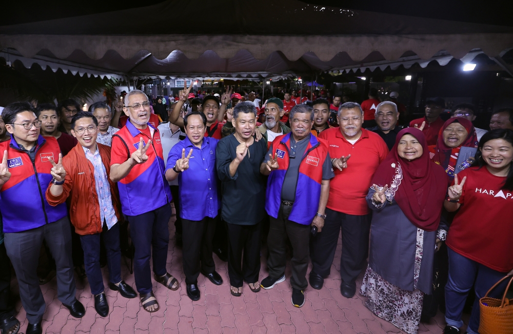 Amanah president Datuk Seri Mohamad Sabu (fourth from right), Johor Umno deputy chairman Datuk Seri Ahmad Maslan (fourth from left), PH candidate for the Simpang Jeram by-election Nazri Abdul Rahman (centre) pose for a group picture after a ceramah at Taman Sri Kasih, in Muar August 28, 2023. — Bernama pic 