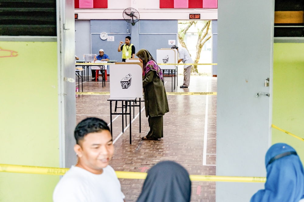 A voter fills out a ballot at a polling station during the Selangor state election at SK Klang Gate August 12, 2023.  In a report released today, Nusantara Academy for Strategic Research said that BN could not retain the backing of its supporters even in constituencies previously contested. — Picture by Firdaus Latif