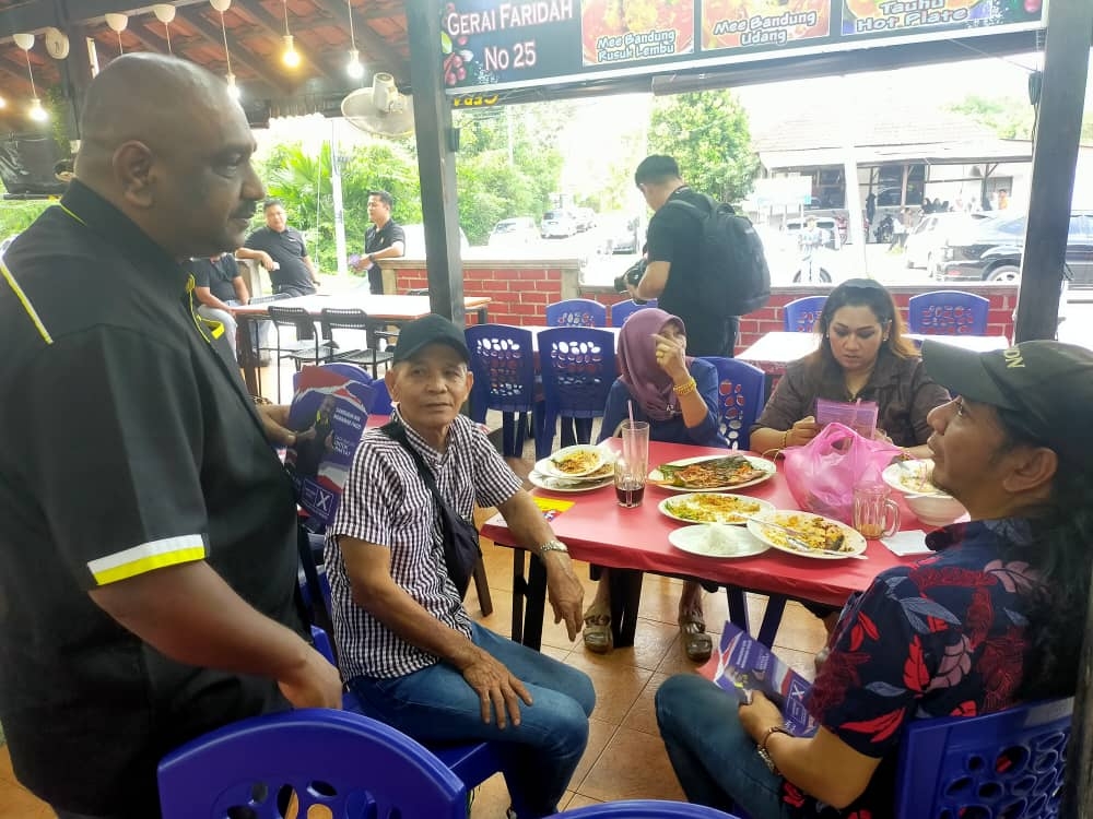 Pulai parliamentary by-election independent candidate Samsudin Mohamad Fauzi (far left) campaigns at a restaurant in Kempas, Johor Baru August 29, 2023. — Picture by Ben Tan