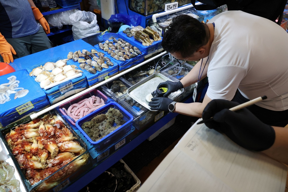 An official measures radiation levels of scallops imported from Japan as they conduct a radioactivity check, which have been conducted regularly since the 2011 Fukushima disaster, at Noryangjin fisheries wholesale market in Seoul, South Korea, July 6, 2023. — Reuters pic