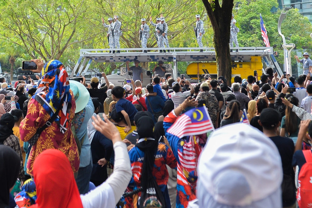 People wave the Jalur Gemilang as they watch the Merdeka Day parade in Putrajaya August 31, 2023. ― Picture by Miera Zulyana