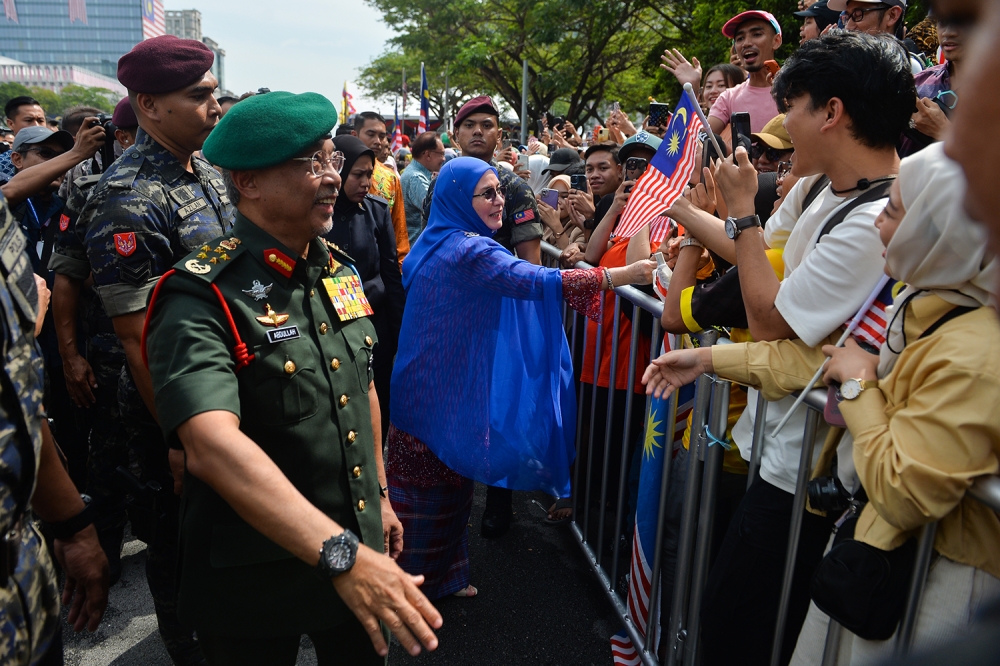 The Yang di-Pertuan Agong and Raja Permaisuri Agong stopped to chat, shake hands and take selfies with the parade participants and visitors. ― Picture by Miera Zulyana