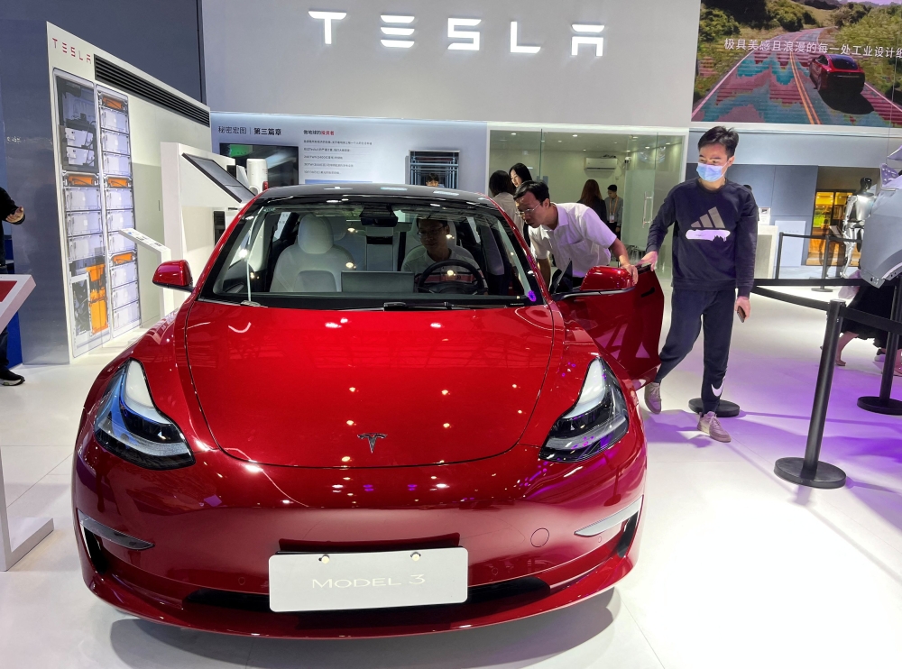 Visitors look at a Tesla Model 3 electric vehicle (EV ) at the third China International Consumer Products Expo, in Haikou, Hainan province, China April 12, 2023. — Reuters pic