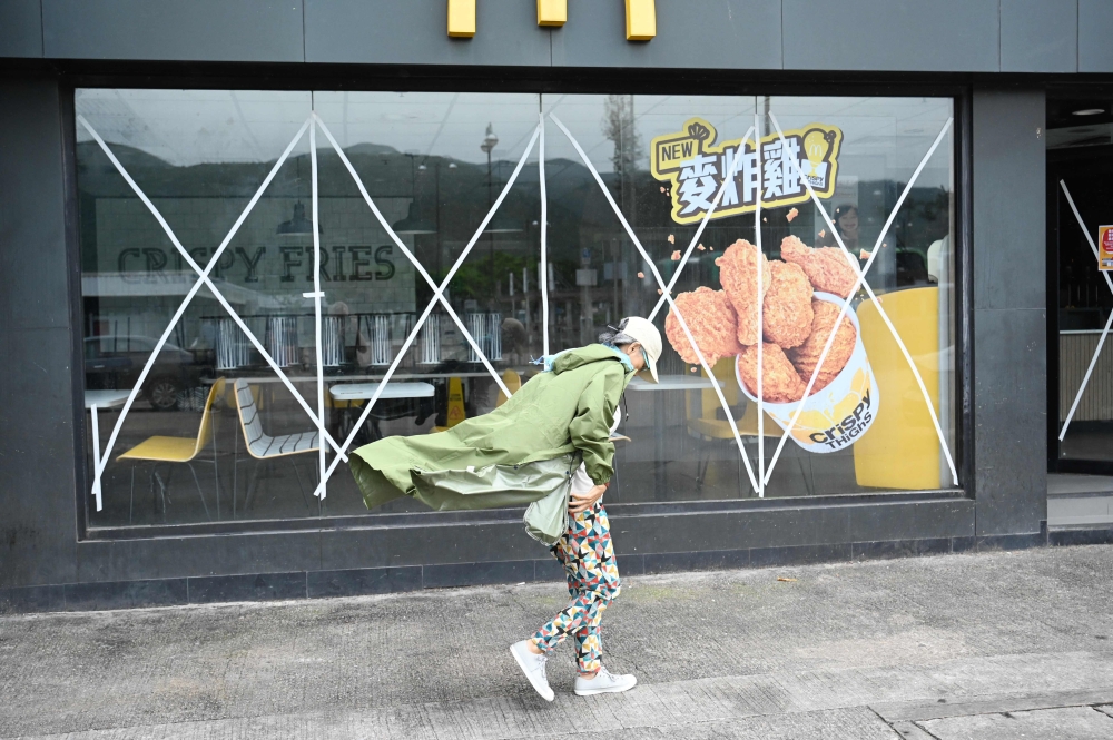 A closed fast food outlet with windows taped up for protection in Hong Kong. — AFP pic