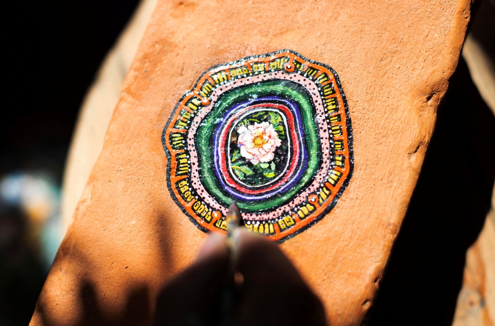Ben Wilson, shows his painting on a piece of chewing gum, stuck on a brick, in his home studio in Muswell Hill, London, Britain, August 21, 2023. — Reuters pic