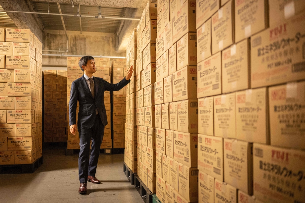 Takashi Hosoda, head of disaster management at Mori Building, posing for photographs at the emergency supply warehouse of Roppongi Hills Mori Tower in Tokyo. — AFP pic