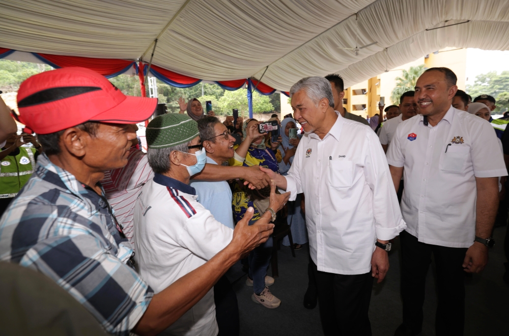 Deputy Prime Minister who is also Minister of Rural and Regional Development Datuk Seri Dr Ahmad Zahid Hamidi accompanied by Chairman of the Johor State Housing and Local Government Committee Datuk Mohd Jafni Md Shukor (right) shaking hands with residents when they attended the Bersama Rakyat Program at the People's Housing Program (PPR) in Kempas Permai, Johor Baru, September 3, 2023. — Bernama pic