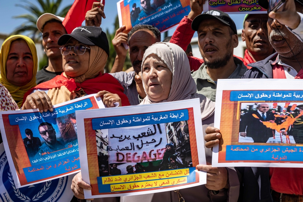 Moroccans carry posters during a demonstration in Rabat on September 4, 2023, condemning the killing of two jet skiers by the Algerian coastguard after they strayed across the maritime border between the two countries. — AFP pic