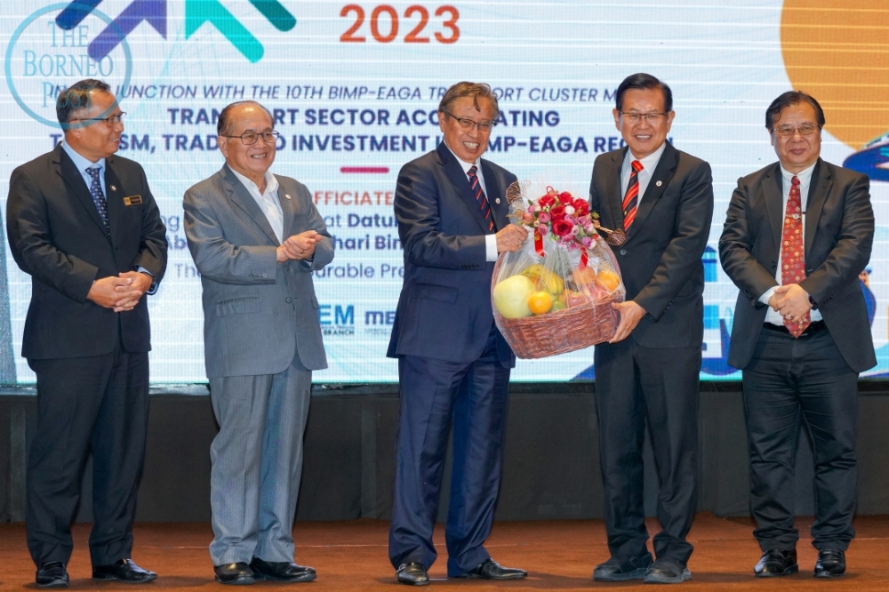 Abang Johari (centre) receives a token of appreciation from Lee while (from left) Abu Bakar, Uggah and Dr Jerip look on. – Borneo Post pic