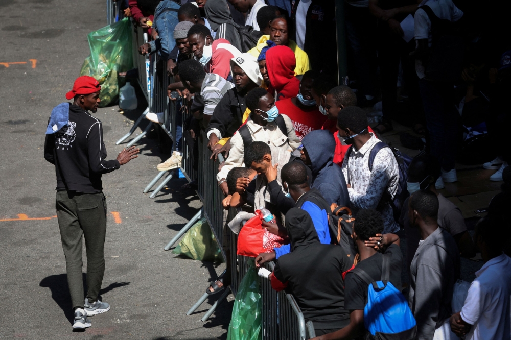 Recently arrived migrants to New York City wait on the sidewalk outside the Roosevelt Hotel in Manhattan, where a temporary reception centre has been established in New York City August 1, 2023. — Reuters pic