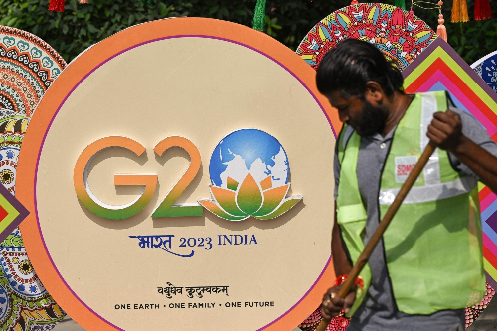 A municipal worker cleans a road near a G20 India summit logo ahead of its commencement in New Delhi on September 3, 2023. — AFP pic