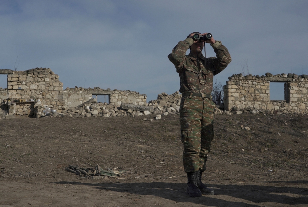 File photo of an ethnic Armenian soldier looking through binoculars as he stands at fighting positions near the village of Taghavard in the region of Nagorno-Karabakh, January 11, 2021. Picture taken January 11, 2021.— Reuters pic