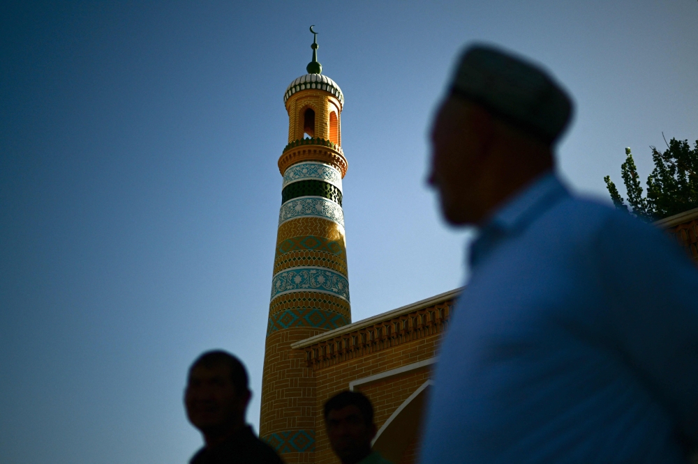 Uyghur people outside of the Id Kah Mosque in Kashgar city, north-western China's Xinjiang region. In Kashgar, no more than two dozen mostly elderly Uyghur men were seen entering the mosque for Friday afternoon prayers, vastly outnumbered by tourists — a stark change from the thousands of believers that would congregate a decade ago. — AFP pic 