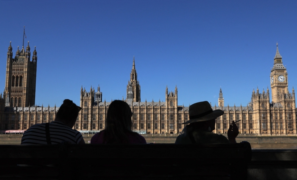 People look out across the River Thames at the Palace of Westminster, home to the Houses of Parliament — the House of Commons and House of Lords September 4, 2023. A man reported to be a UK parliamentary researcher who was arrested on suspicion of spying for Beijing today denied all accusations. — AFP pic