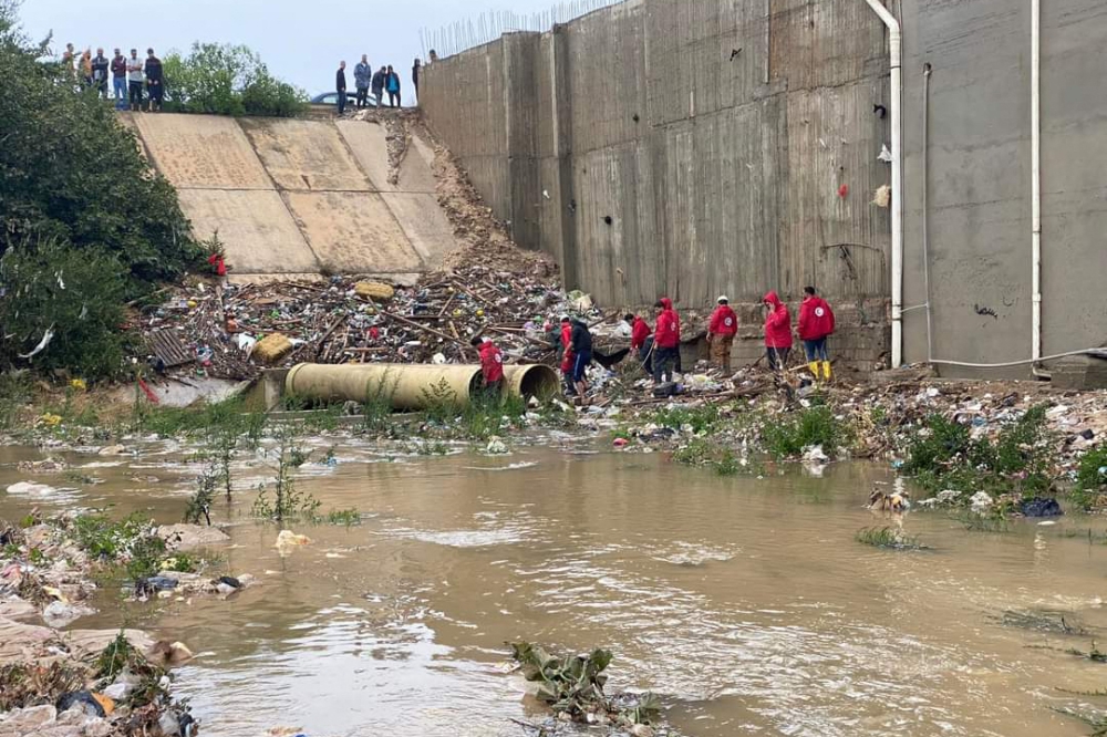 This picture released by the Libyan Red Crescent on September 11, 2023, shows members of their team working on opening roads engulfed in floods at an undefined location in eastern Libya. — Libyan Red Crescent/HO/AFP pic
