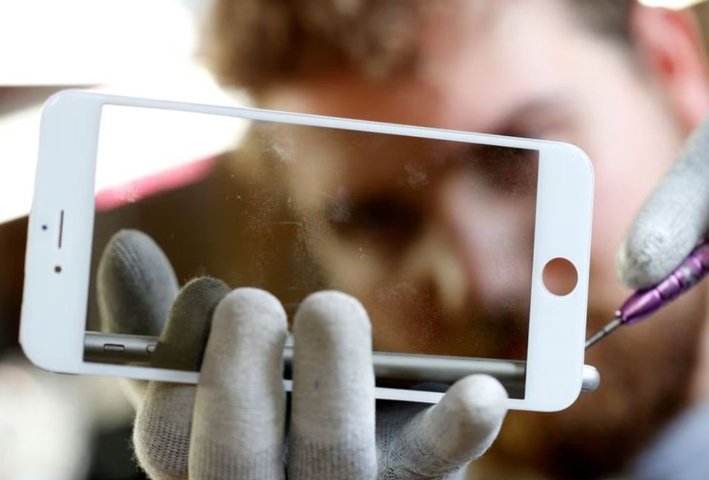 A worker refurbishes an Apple Iphone cell phone at a workshop of the Oxflo company, specialised in refurbishment of broken European smartphones which will be resold and provided with a warranty as part of an eco-responsible approach, in Lusignac, France, June 20, 2019. — Reuters pic