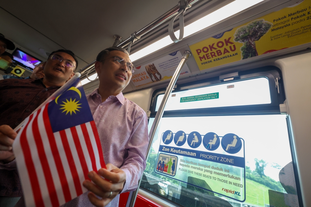 Communications and Digital Minister Fahmi Fadzil (2nd left) looks at specially decorated LRT coaches for Malaysia Day during their launch at the KLCC LRT station in Kuala Lumpur September 13, 2023. — Bernama pic