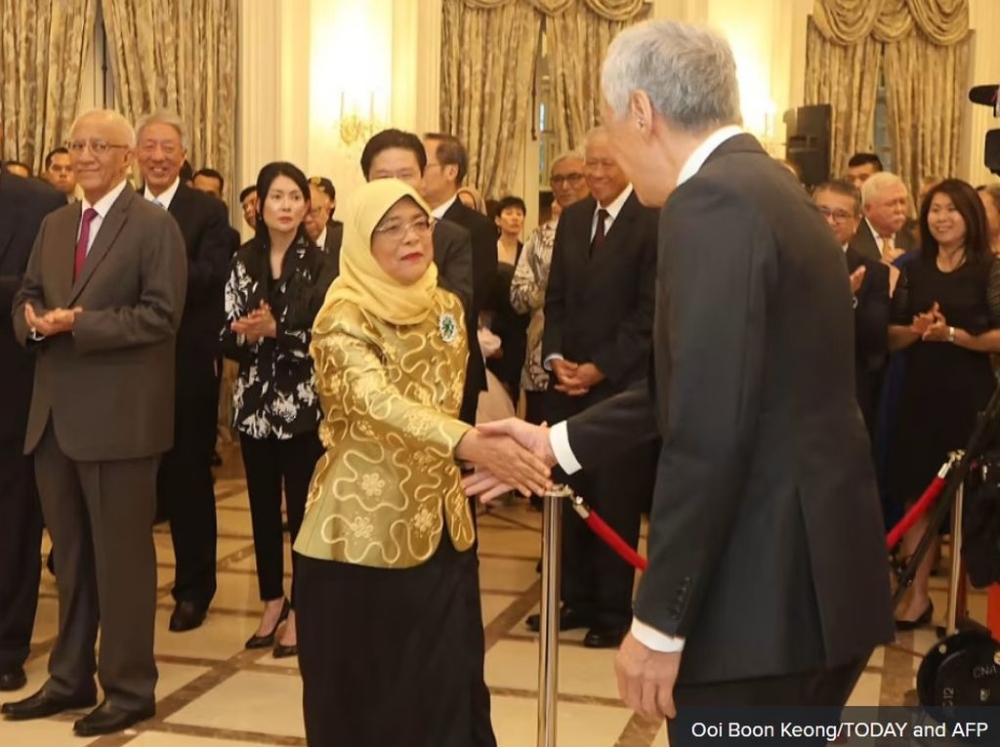President Halimah Yacob shaking the hands of Prime Minister Lee Hsien Loong at the Istana on Sept 13, 2023. — TODAY pic