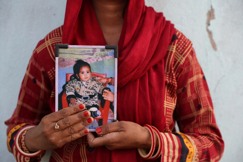 Poli Devi, whose 11-month-old daughter Janvi was among the children who died due to kidney injury after consuming contaminated cough syrup, holds a photo of her at their house in Ramnagar on the outskirts of Jammu March 28, 2023. — Reuters pic