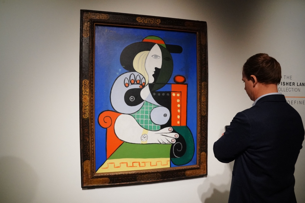A visitor looks over Pablo Picasso's “Femme a la montre” which is expected to fetch at least US$120 million. — AFP pic