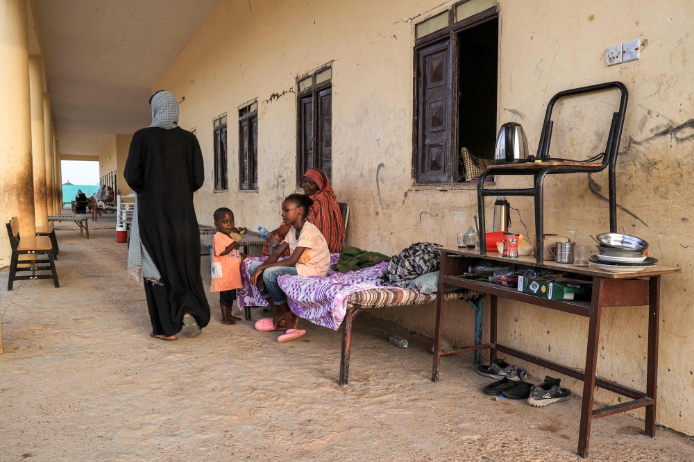 Women and children sit outside a classroom at a school that has been transformed into a shelter for people displaced by conflict in Sudan's northern border town of Wadi Halfa near Egypt September 11, 2023. — AFP pic