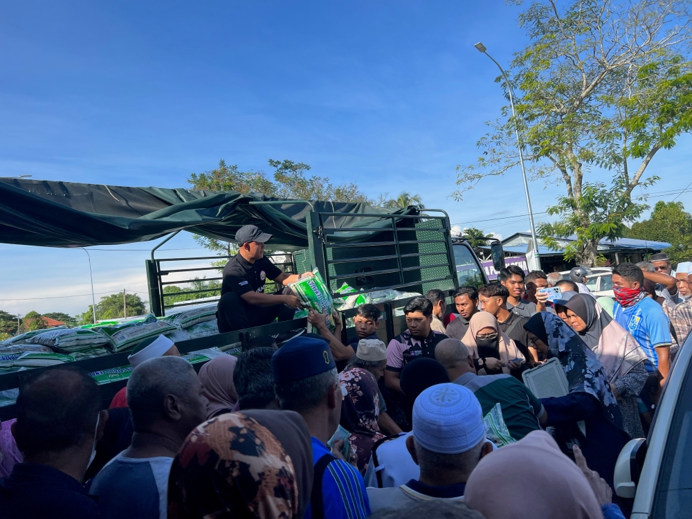 Crowds had gathered as early as 7am to form long queues at the Farmers’ Outlet in Pokok Sena here to buy local white rice that was being sold after Mohamad launched the initiative here. — Picture by Opalyn Mok