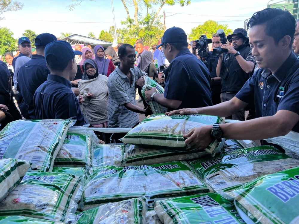 Crowds gather at the Farmers’ Outlet in Pokok Sena here to buy local white rice under the intervention initiative here. — Picture by Opalyn Mok