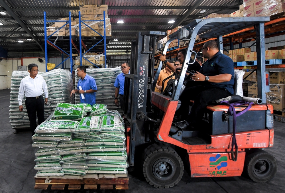 State Agriculture, Food Security and Cost of Living Committee chairman Datuk Seri Jalaluddin Alias (left) inspects the sales process of the local white rice sales programme at the Fama Senawang operations centre, September 20, 2023. — Bernama pic 