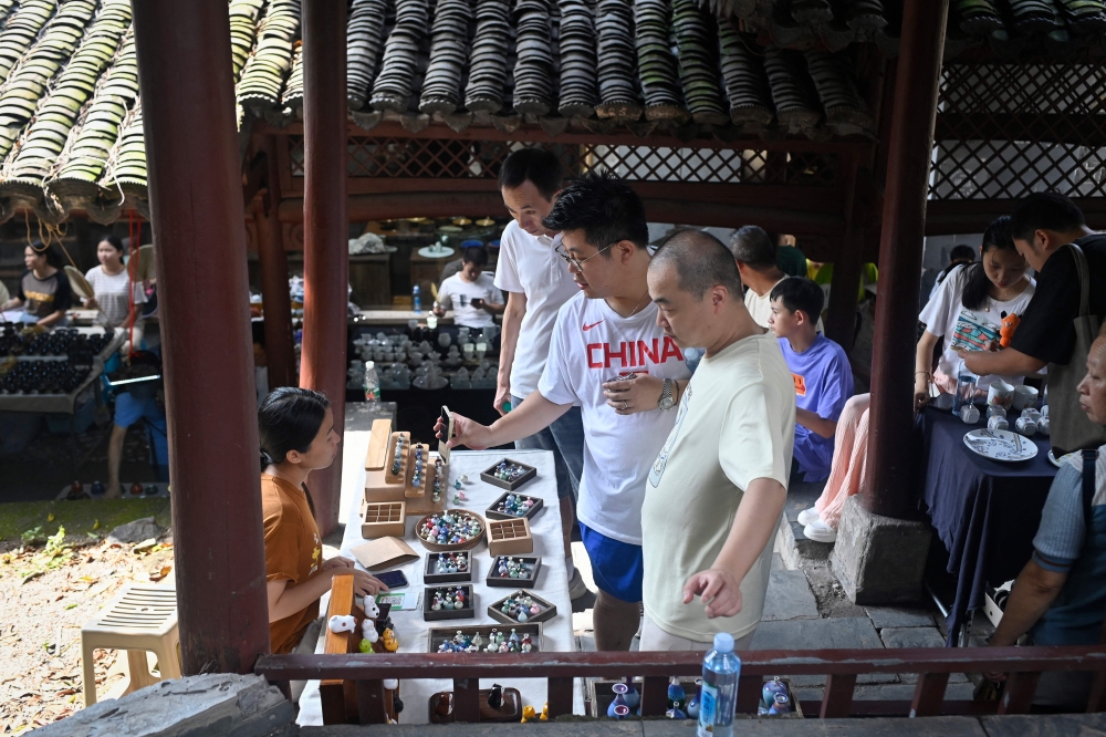 This picture taken on August 26, 2023 shows people visiting a market in Jingdezhen. — AFP pic