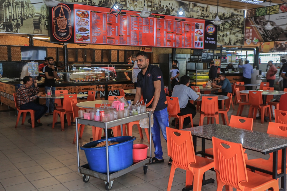 A foreign worker at a food court in Green Town, Perak. In response to a recent news portal article concerning foreign workers from Bangladesh, Human Resources Minister V Sivakumar said employers will determine selection of workers and the source of country based on their suitability in adapting to the nature of work of their respective industries. — Picture by Farhan Najib