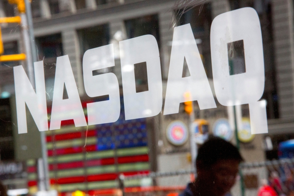 A man walks past the Nasdaq MarketSite in New York's Times Square August 23, 2013. — Reuters pic