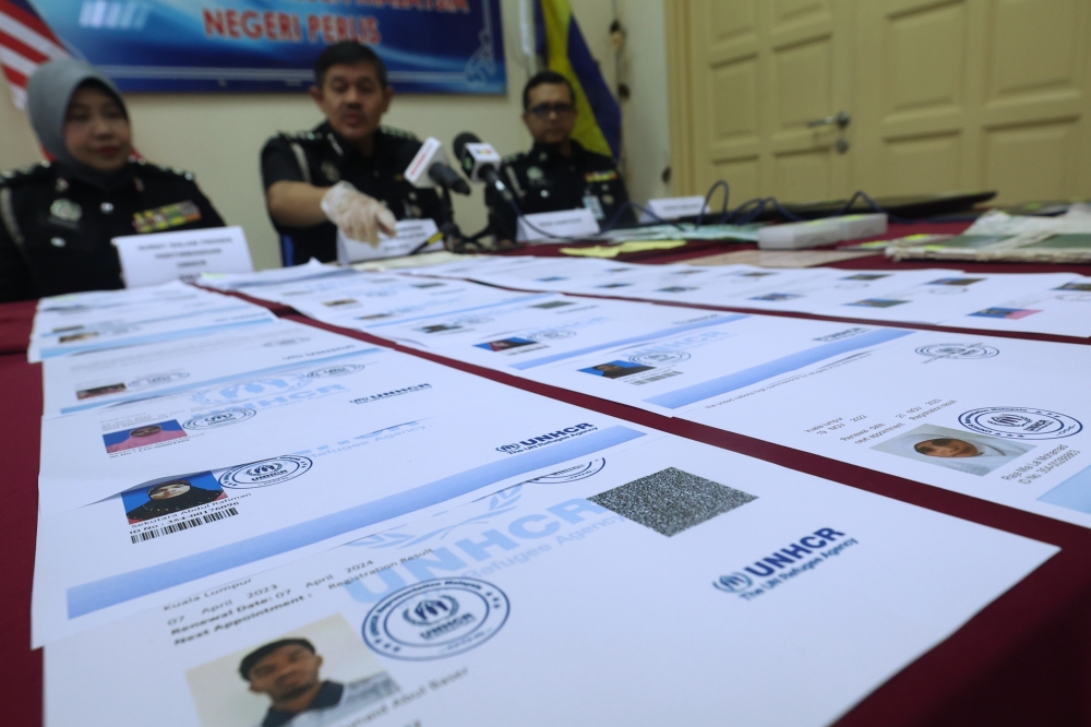 Perlis Immigration director Khairul Amin Talib shows the UNHCR consideration letters at a press conference on the document forging operation run by a Rohingya couple in Kangar, September 22, 2023. — Bernama pic 