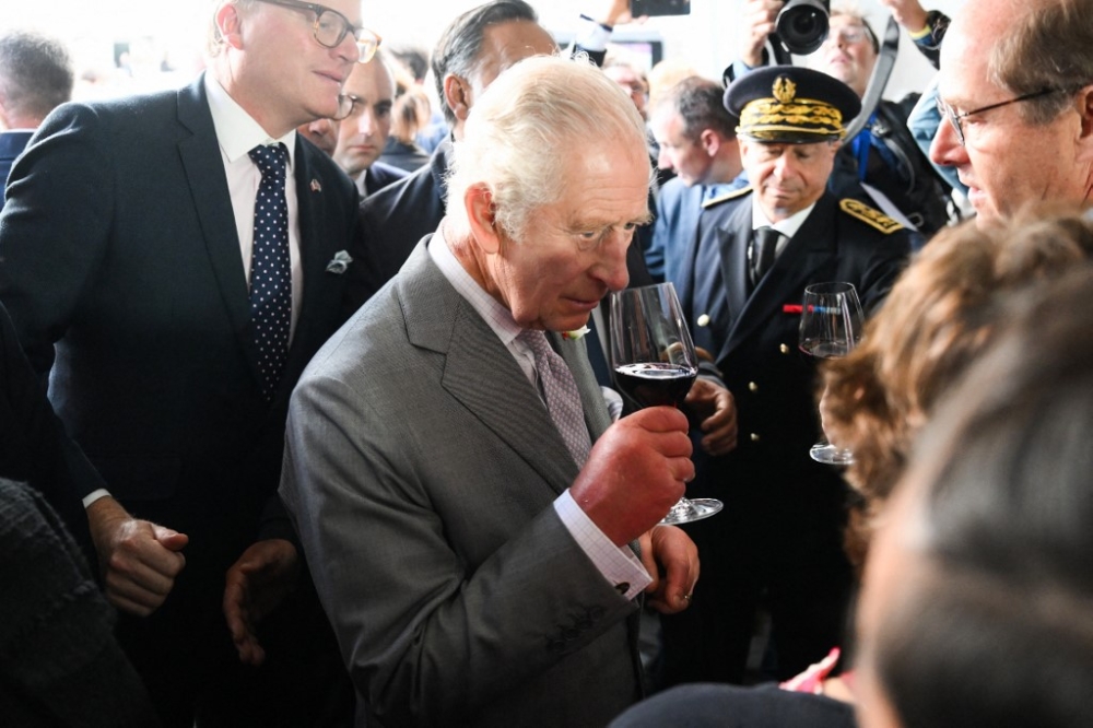 Britain's King Charles III smells some wine during a visit to a festival in celebration of British and French culture and business at Place de la Bourse in Bordeaux, southwestern France, on September 22, 2023. — AFP pic