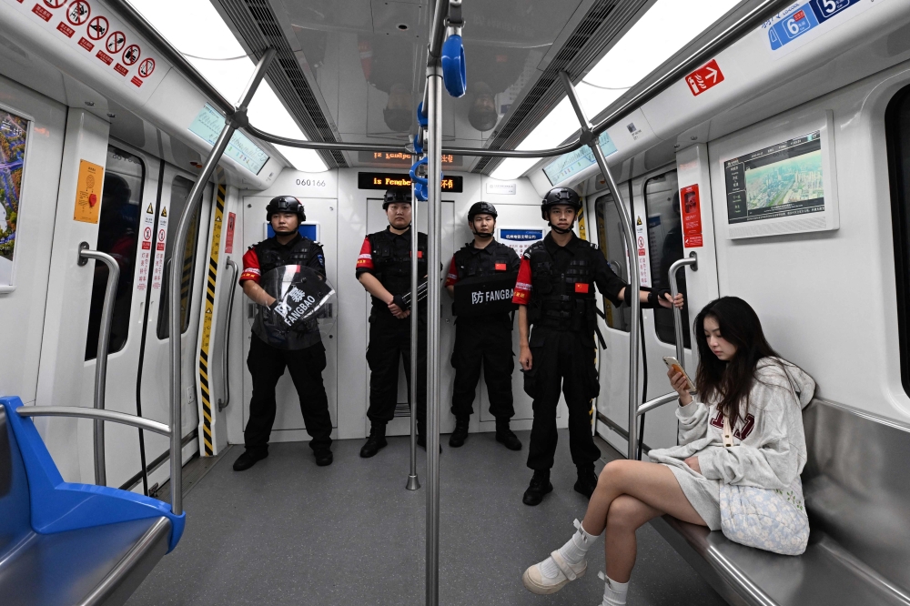Chinese policemen ride a subway train while on patrol in Hangzhou in China’s eastern Zhejiang province on September 22, 2023. — AFP pic