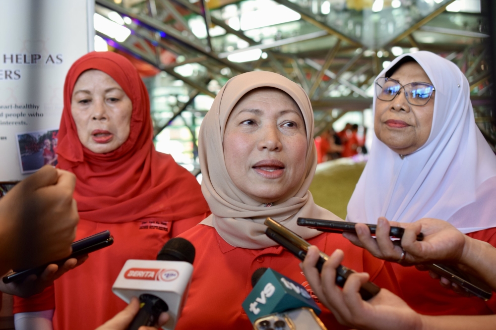 Nancy speaking to reporters after officiating the World Heart Day at Pustaka today. Also seen are Jamilah (left) and Rohani (right). — Borneo Post pic