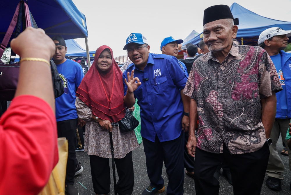 Barisan Nasional (BN) candidate Datuk Amizar Abu Adam with his father Abu Adam Duaji (right) at the Felda Chemomoi night market site during the N State Assembly (DUN) by-election (PRK) campaign, in Bentong, September 25, 2023. — Bernama pic 