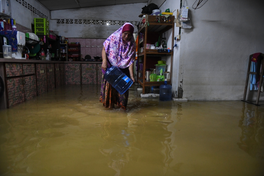 Azizah Rehab, a 62-year-old homemaker, at her flooded home on Jalan Kampung Masjid, Teluk Kumbar, Balik Pulau, September 25, 2023. — Bernama pic  