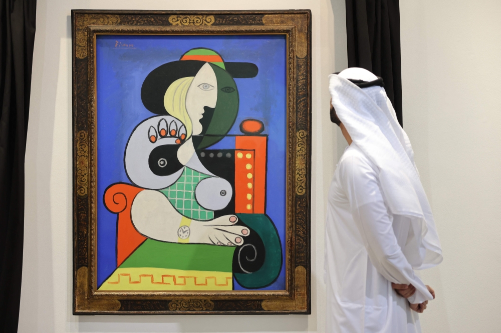 A visitor looks at Pablo Picasso’s painting ‘Femme a la montre’ in Dubai September 25, 2023. — AFP pic