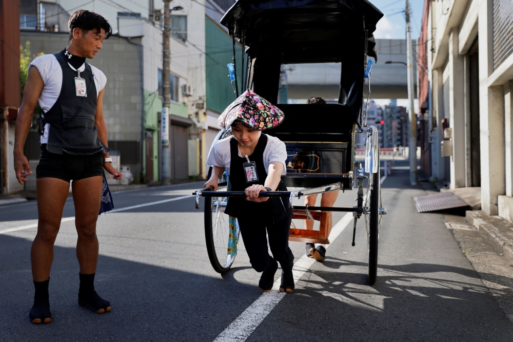 Trainee Yumeka Sakurai, 20, receives rickshaw driving lessons from her colleagues in the Asakusa district, Tokyo, Japan, August 17, 2023. — Reuters pic